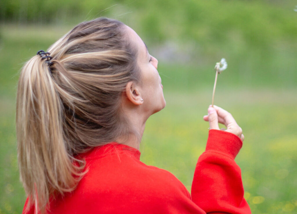 Girl blowing flower